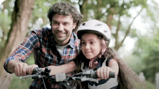 Parent teaching child to ride bike